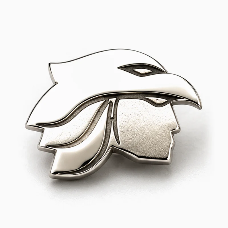 Pin troquelado plateado del perfil de un guerrero bajo un tocado de cabeza de águila, con bordes pulidos en relieve y rostro con textura
