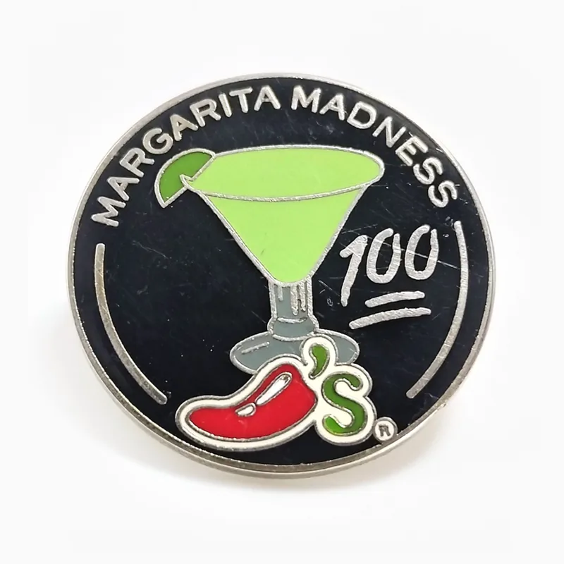 Pin redondo de esmalte duro negro con una copa de margarita verde y un chile rojo, hecho para una cadena de restaurantes.