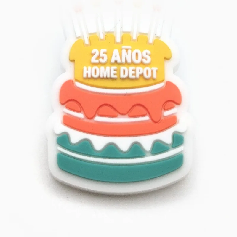 Pin de PVC con forma de pastel de cumpleaños de varios pisos y la frase “25 años” arriba, hecho para una cadena de artículos para el hogar y construcción.