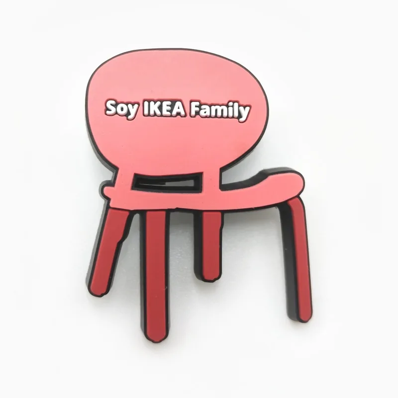 Pin de PVC rojo con forma de silla y texto en español, hecho para una cadena de muebles.
