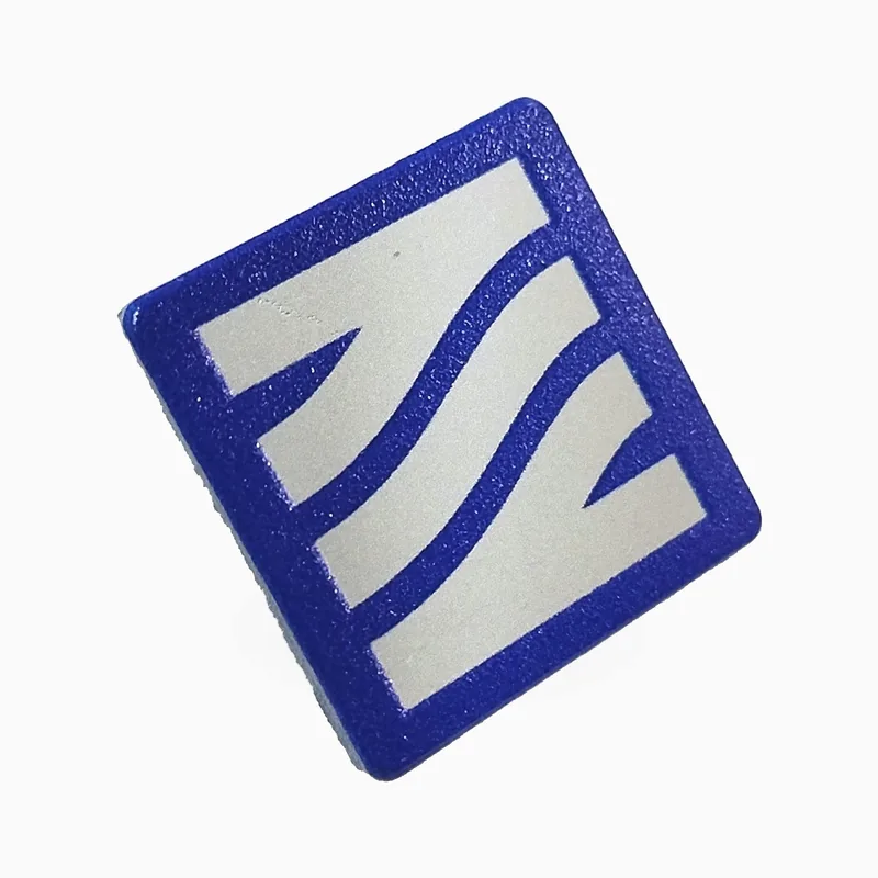 Pin cuadrado con impresión UV de franjas onduladas blancas sobre un fondo azul cepillado