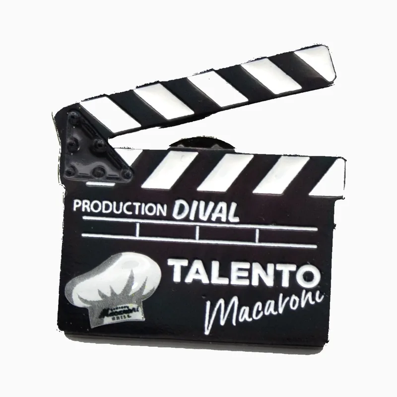 Pin impreso negro de una claqueta de cine con marcas blancas y el texto TALENTO México