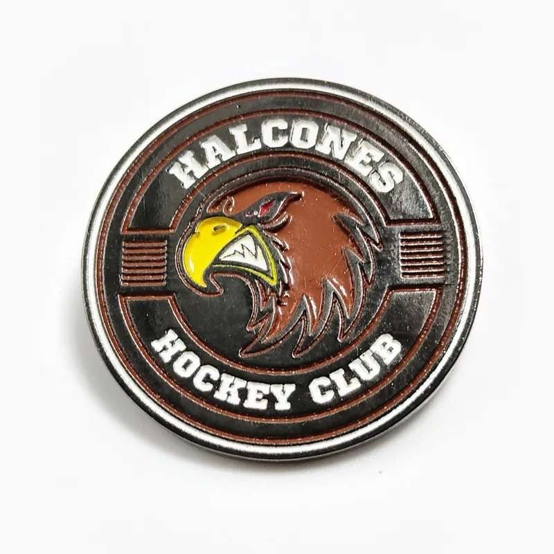 Pin redondo de esmalte suave de un club de hockey con una cabeza de águila en esmalte café y dorado dentro de un aro de letras en relieve