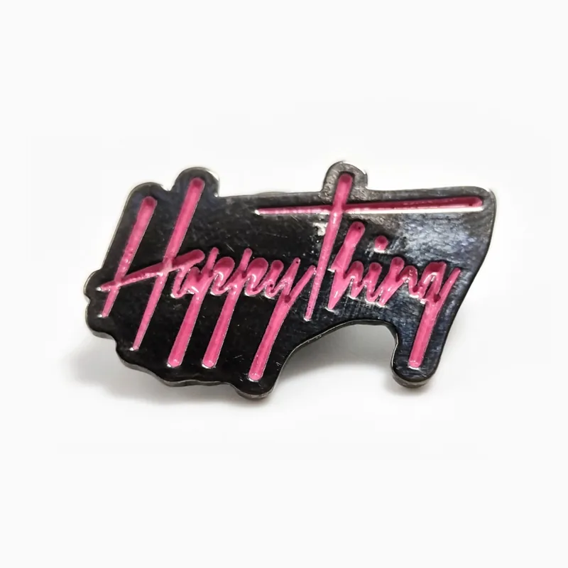 Pin de esmalte suave con el texto Happy Thing en letras cursivas rosas y moradas estilo neón